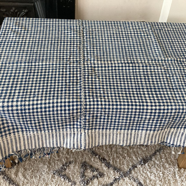 Photo of a black and white, handwoven fabric laid on a table